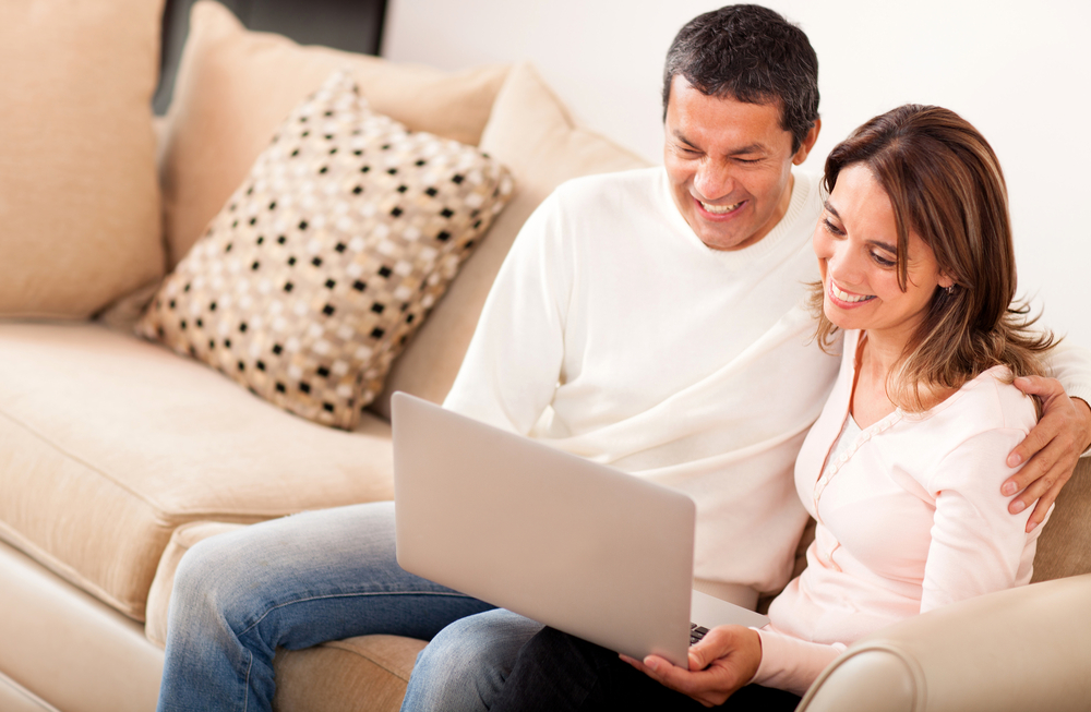 Couple at home going online on a laptop computer